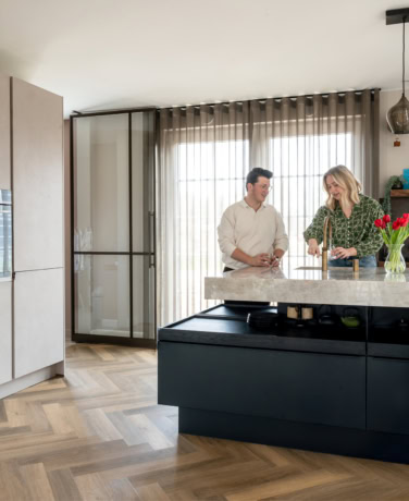Moderne stalen deuren in keuken met grote ramen en natuurlijke lichtinval, perfect voor een eigentijdse woning, op maat gemaakt door Aluwdoors.