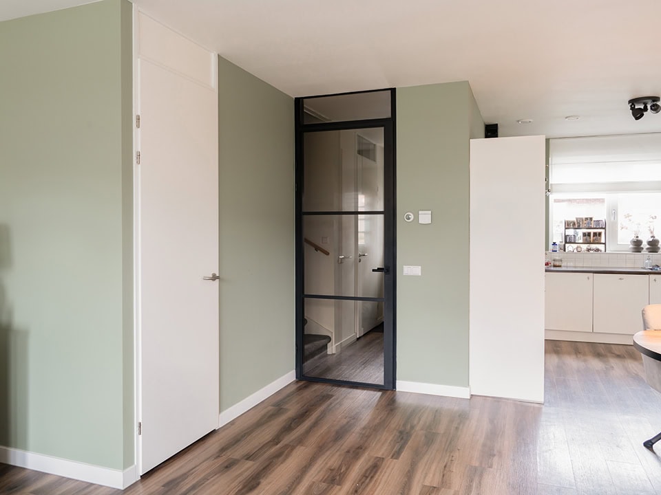 Hoogwaardige stalen deur met glas in een modern interieur, perfect voor op maat gemaakte deuren en wanden, passend bij Aluwdoors.