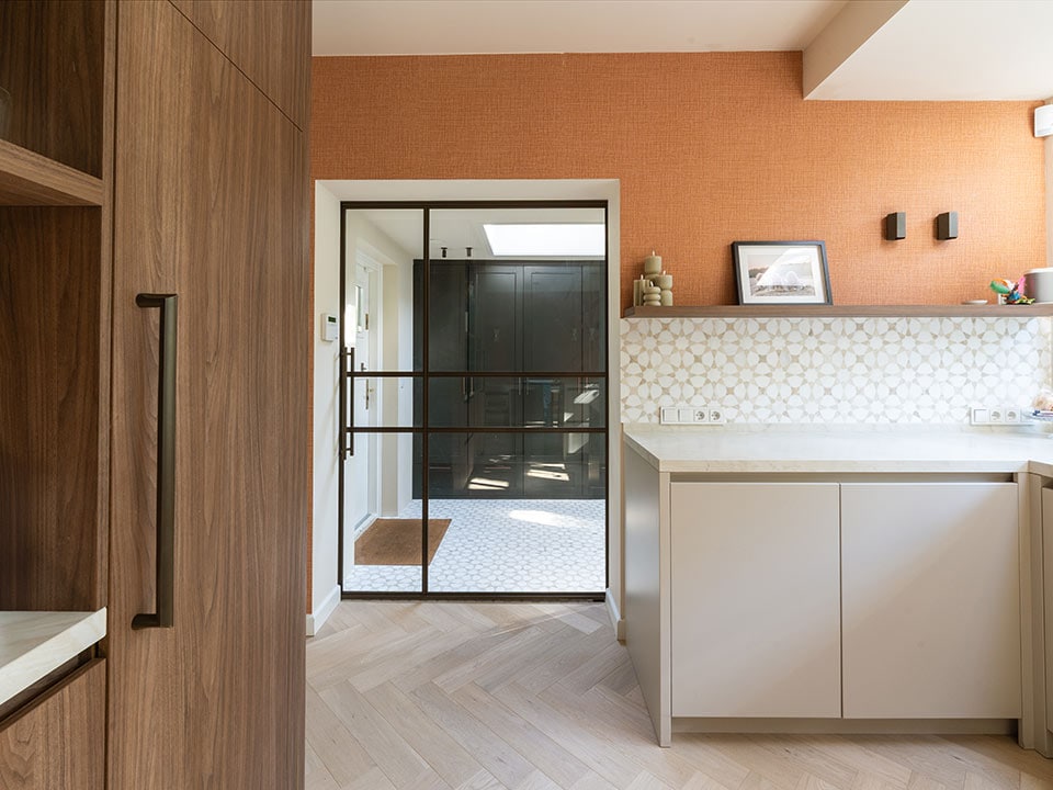 Hoogwaardige stalen deur op maat in een moderne keuken met warme kleuren en natuurlijke materialen, perfect voor een stijlvolle woning.