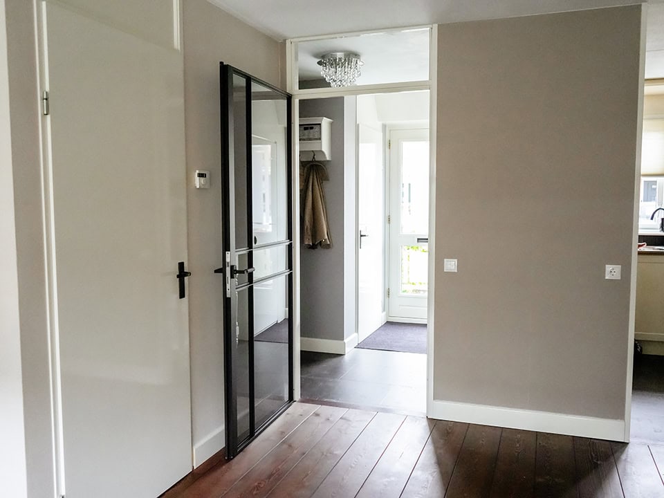 Moderne rebate stalen deur in een eigentijdse woning, perfect voor scheiding van ruimtes met een strak en industrieel design.