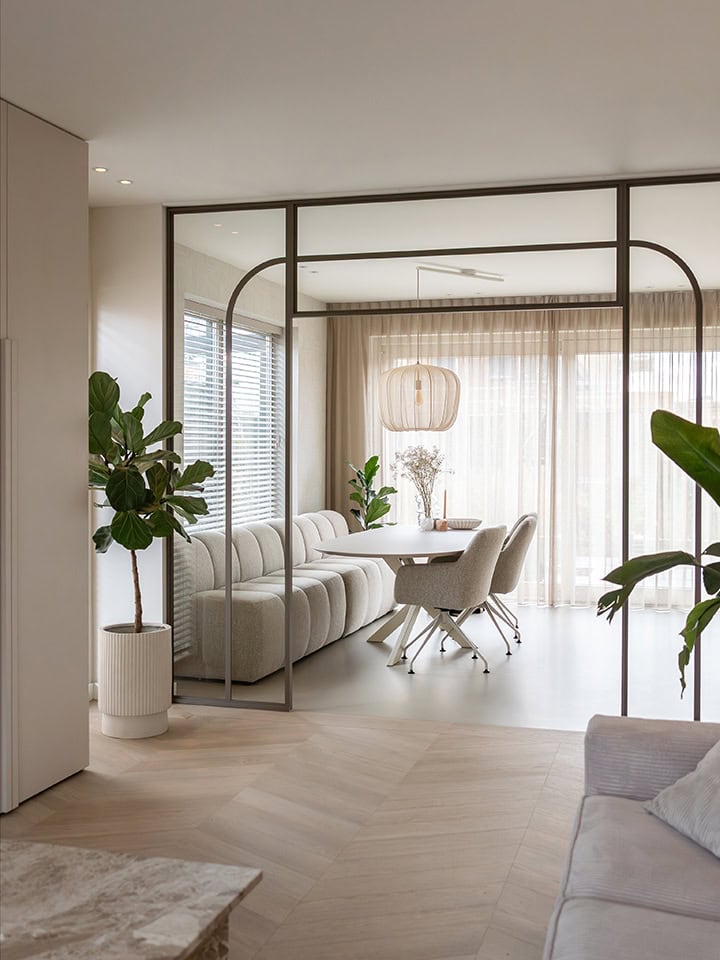 Elegante stalen scheidingswand met glazen panelen in een lichte, moderne woonkamer, ideaal voor het creëren van aparte ruimtes met een stijlvolle uitstraling.