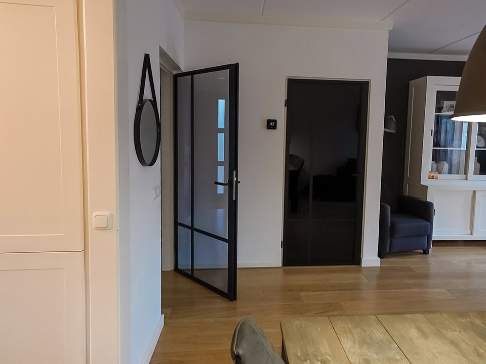 Moderne woning met op maat gemaakte stalen deur met rebate, strakke afwerking en minimalistisch design, perfect voor een eigentijdse uitstraling.