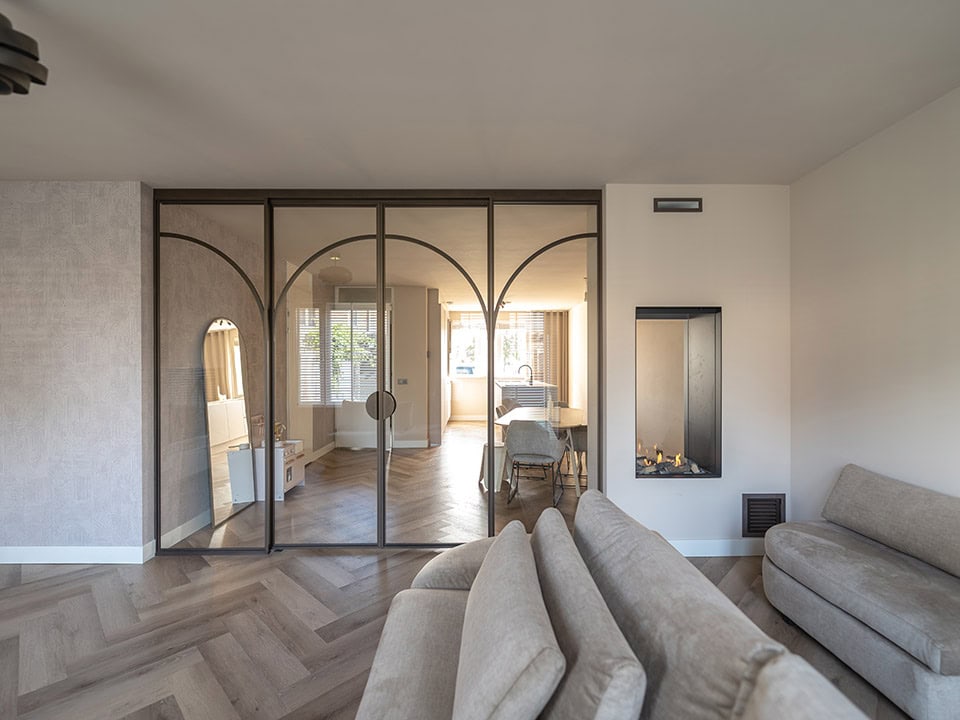 Luxe stalen schuifdeur met glazen panelen in een modern interieur, ideaal voor scheiding van ruimtes en het toevoegen van stijl aan uw woning.