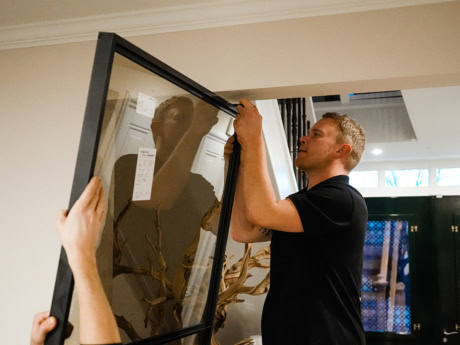 Man monteert een stalen schuifdeur met glas in een modern interieur, onderdeel van de hoogwaardige stalen deuren en wanden op maat van Aluwdoors.
