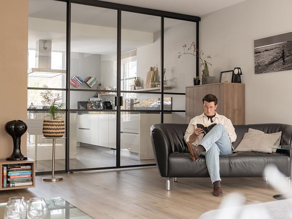 Interieur met stalen deuren en wanden op maat, moderne en strakke afwerking, geschikt voor woon- en werkruimtes, met natuurlijke lichtinval en stijlvolle inrichting.