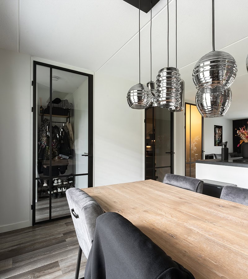 Strakke stalen deur met glazen panelen in een modern interieur, ideaal voor scheiding van ruimtes en het toevoegen van industriële stijl.