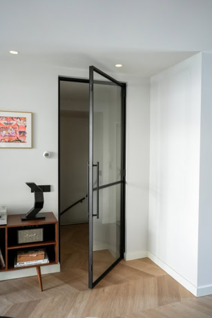 Moderne stalen deur met zwart frame en glas, perfect voor interieur en scheidingswanden, op maat gemaakt door Aluwdoors.