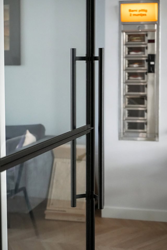Moderne stalen deur met zwart frame en handvat, perfect voor op maat gemaakte stalen deuren en wanden, geschikt voor zakelijke en moderne interieurs.