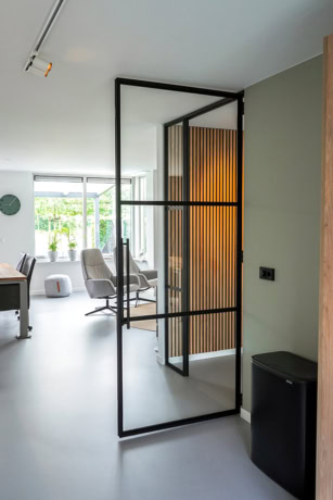 Moderne stalen scheidingswand met houten accent in een eigentijdse interieurruimte, ideaal voor het creëren van aparte zones in een woning of kantoor.