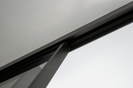 Close-up van een stalen schuifdeur met zwarte afwerking, geĂŻnstalleerd in een modern interieur, benadrukt de kwaliteit en maatwerk van Aluwdoors.