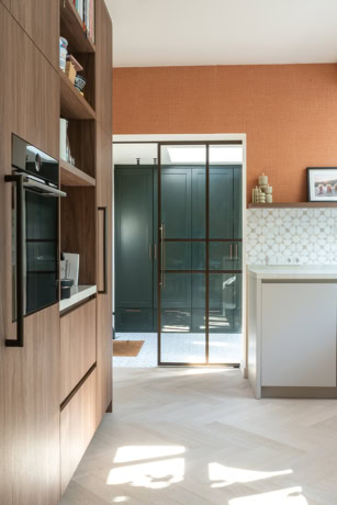 Moderne stalen schuifdeur in keuken met glas en zwarte frame, scheidt de keuken van de buitenruimte, veel natuurlijk licht, stijlvolle en functionele ontwerpkeuze.