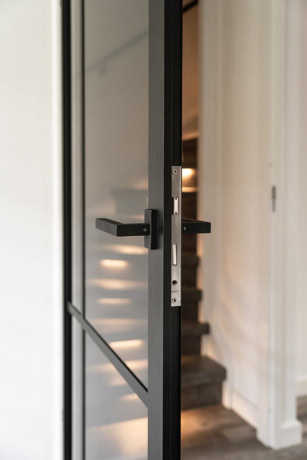 Moderne aluminium stalen deur met zwart frame en glas, perfect voor op maat gemaakte binnen- of buitendeuren, met focus op kwaliteit en design.
